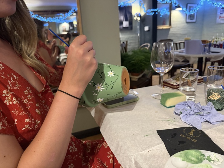 person painting a pot